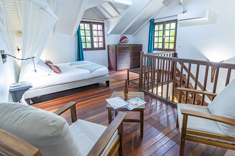 Une chambre avec un lit King Size et un espace confort au Caraïb'Bay Hôtel