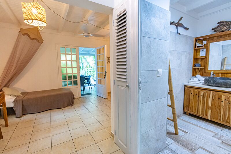 Une chambre avec un lit et une salle de bains au Caraïb'Bay Hôtel