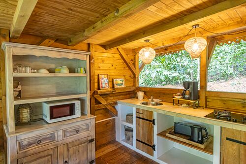 Cuisine équipée avec un frigo, un micro-ondes, des plaques de cuisson, une cafetière et un évier de la villa Kariakou du Caraïb'Bay Hôtel