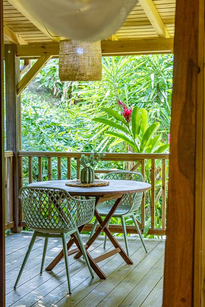 Terrasse extérieure avec une table et deux chaises dans le Caraïb'Bay Hôtel